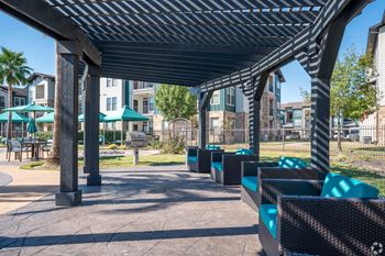 A shaded outdoor seating area with black and green seating.